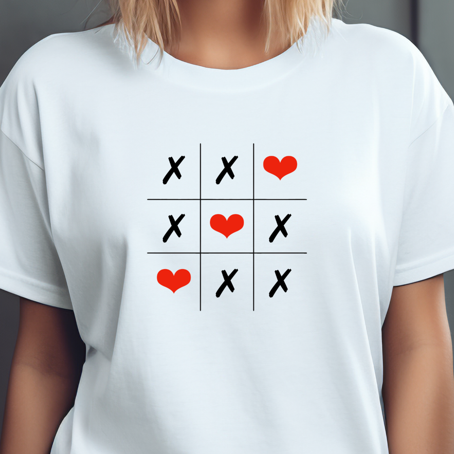 Balti moteriški marškinėliai "Love Game" su kryžiuku ir nuliuku žaidimu, kuriame vietoj nulių naudojamos raudonos širdelės, sukuriant žaismingą ir romantišką dizainą